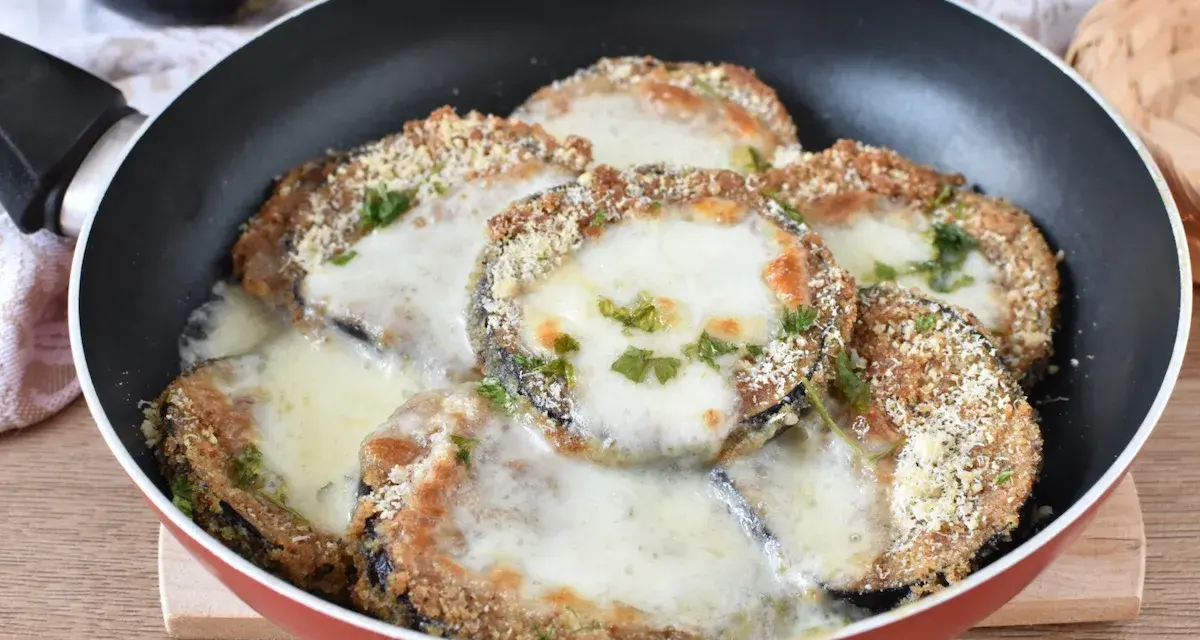 Melanzane in padella con pangrattato e formaggio filante, un piatto gustoso e facile da preparare.