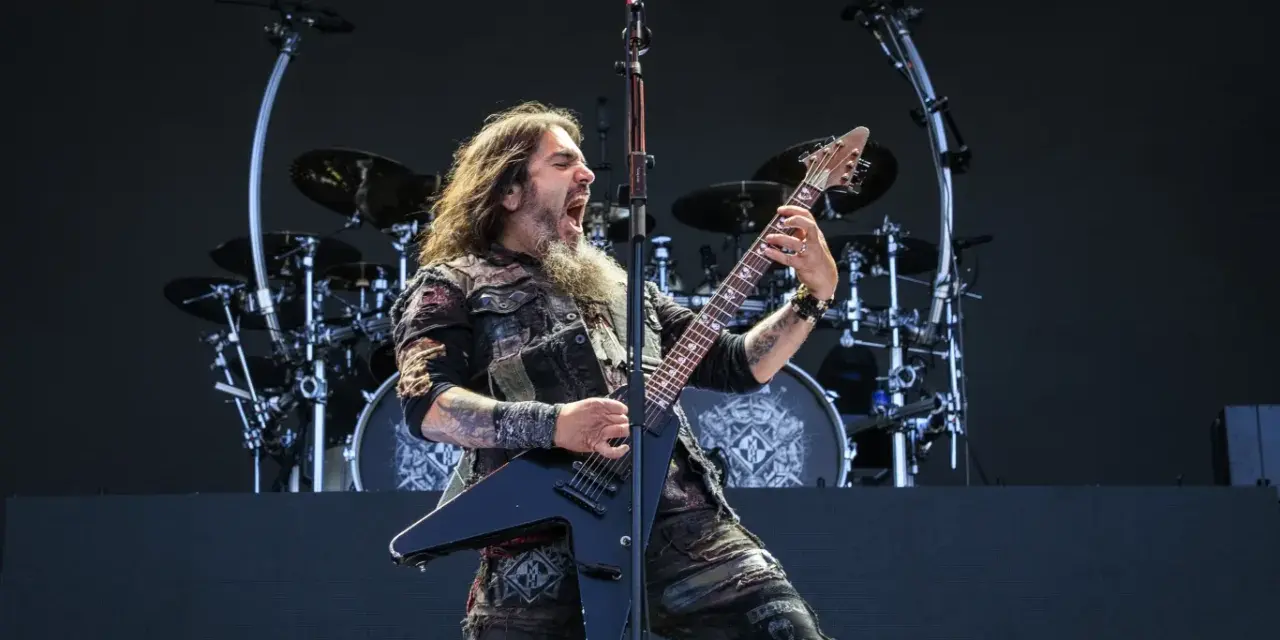 Robb Flynn z Machine Head na jednym z koncertów, w pełni energii, szaleje na czarnej gitarze typu V.