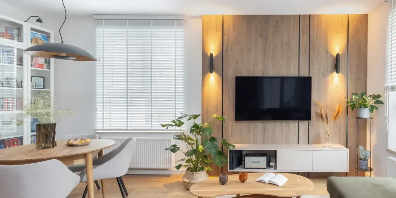 Przytulny salon inspiracje: drewniana ściana z TV, jadalnia, wygodne fotele i stoliki kawowe tworzą ciepłą atmosferę.