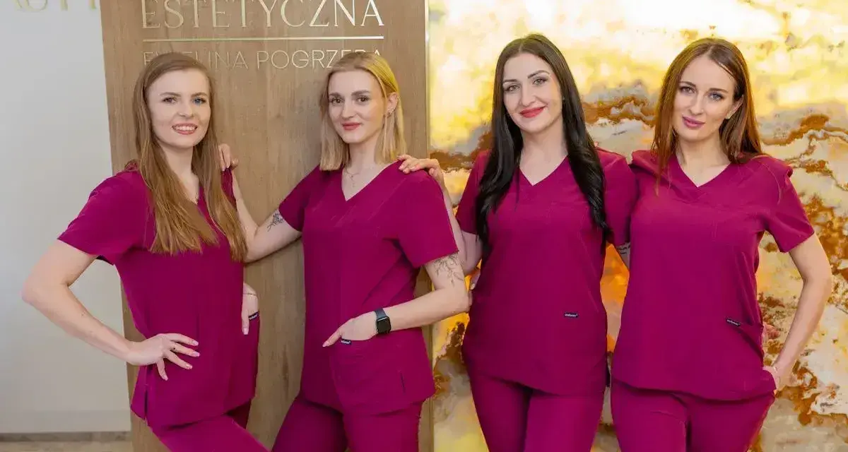 Cztery kobiety w uniformach medycznych stoją obok siebie przed tablicą z napisem "Kosmetologia Estetyczna".
