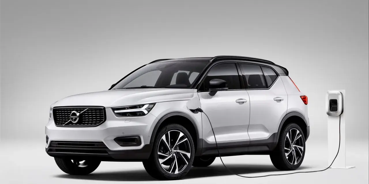 Biały Volvo XC40 Recharge plug-in hybrid podłączony do ładowarki.