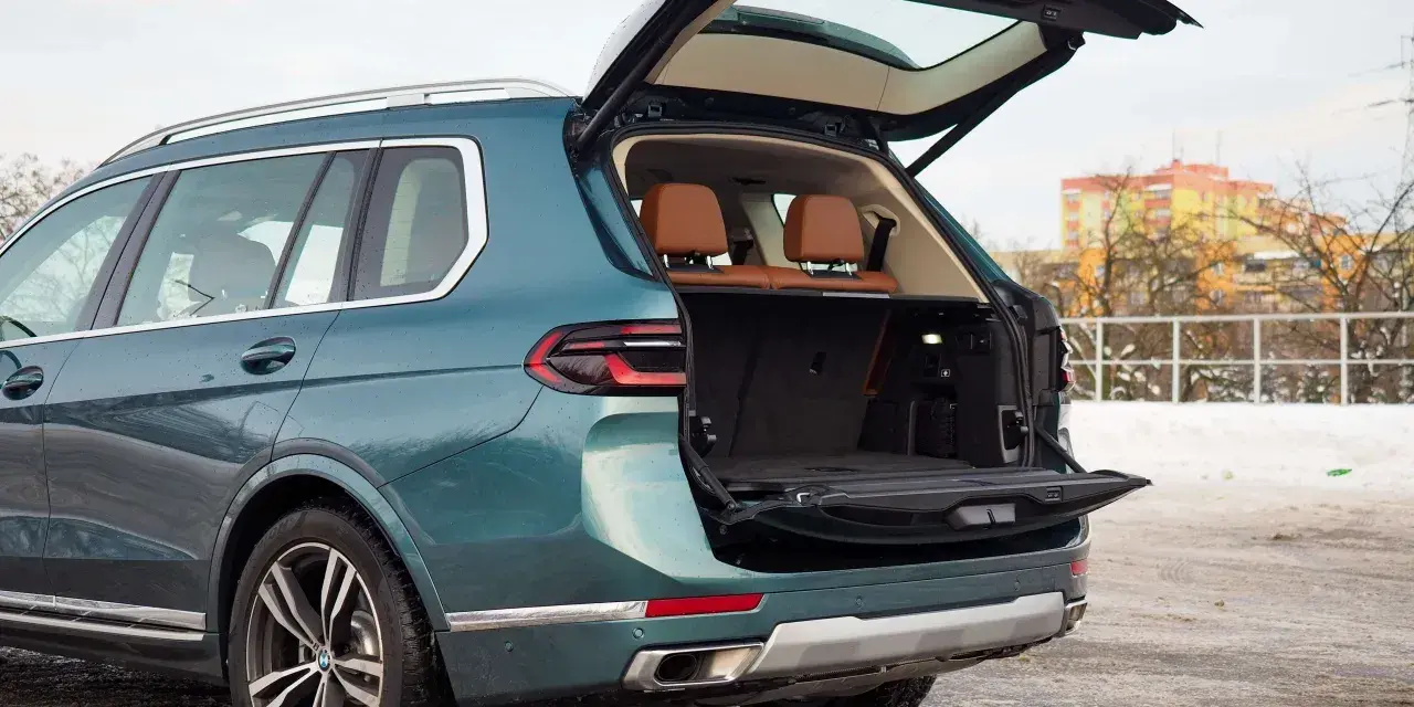 Zielony BMW X7 z otwartym bagażnikiem, idealny na rodzinne wyjazdy. Sprawdź aktualną bmw x7 cena.