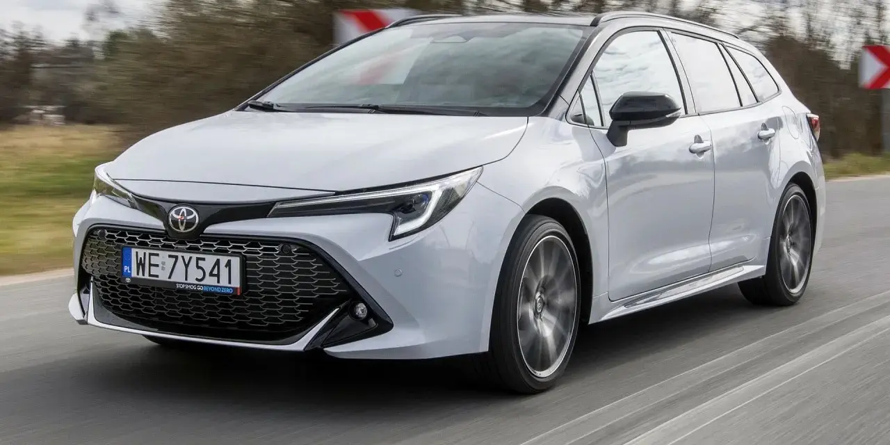 Srebrna Toyota Corolla 2.0 Hybrid w wersji kombi pędzi po drodze.