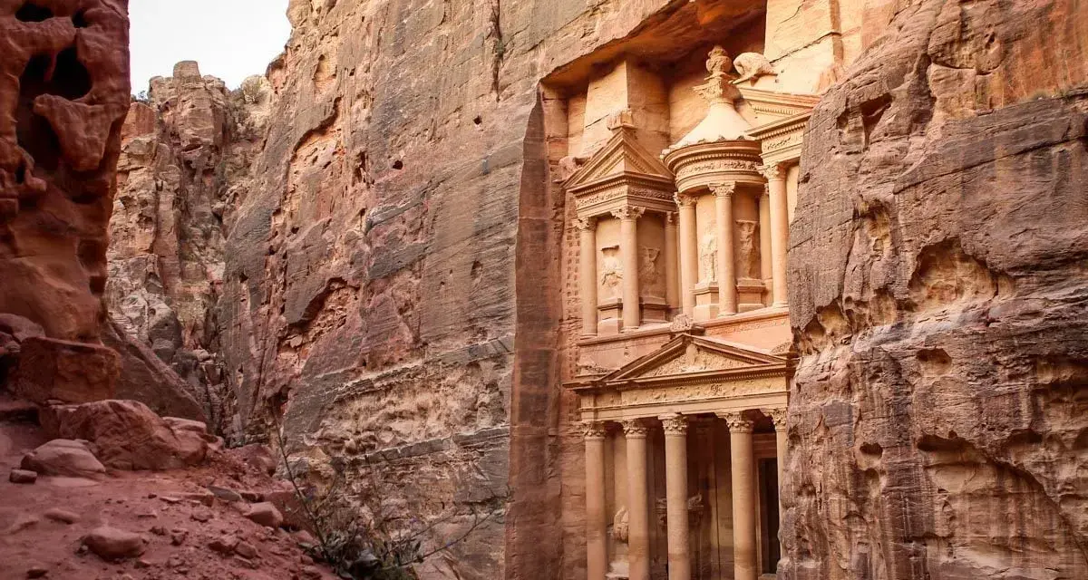 The Treasury in Petra, Jordan, emerges from a narrow canyon. It's a long journey, but how far is Petra from Amman? This ancient city is worth the trip.