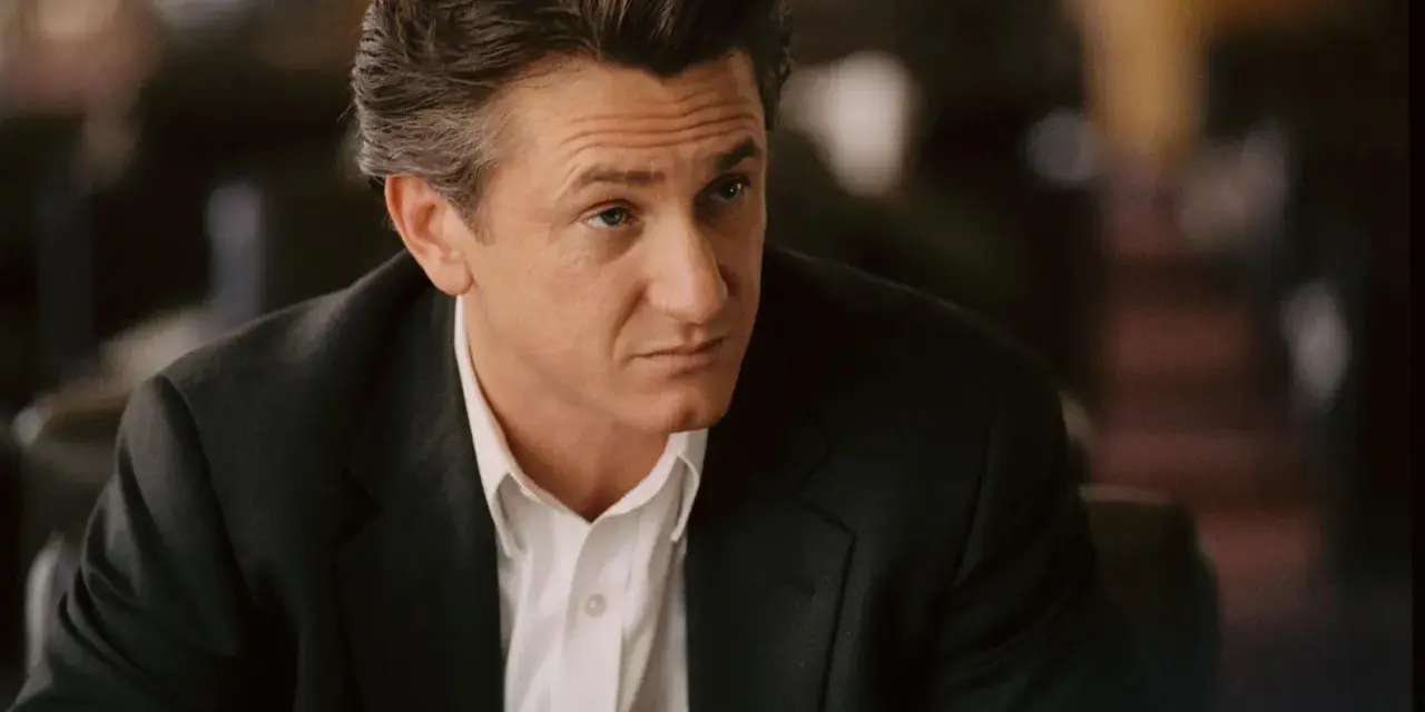 Sean Penn w garniturze, zamyślony. Jego role w filmach zapadają w pamięć.