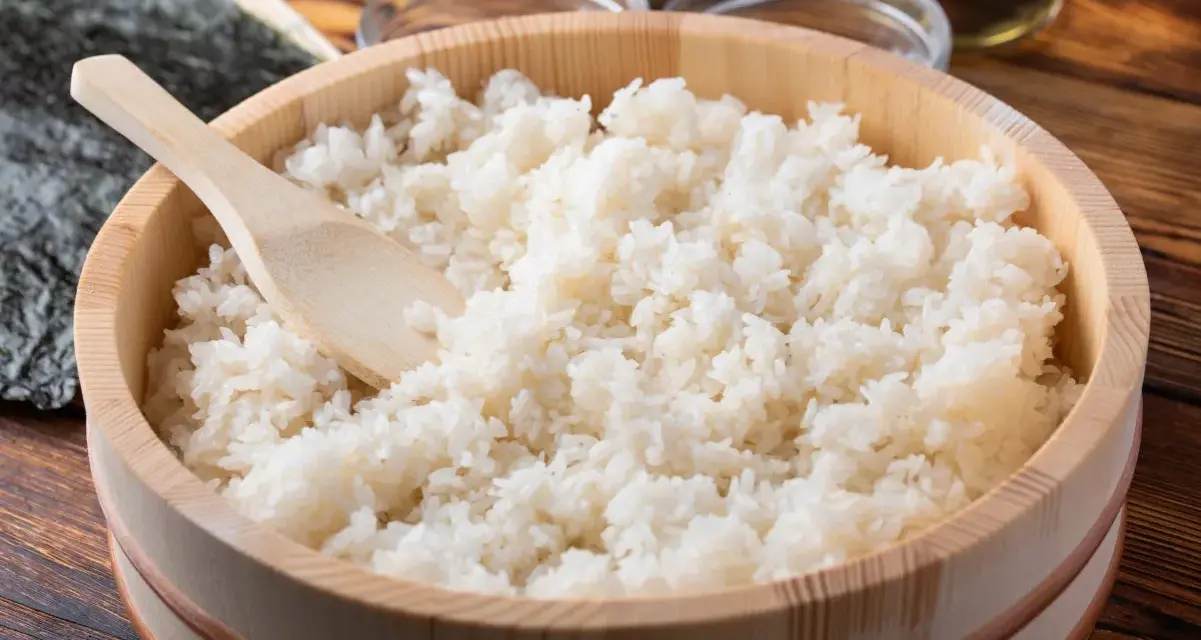 Gotowy ryż do sushi w drewnianym naczyniu, z widoczną drewnianą łopatką. Idealne proporcje dla każdego miłośnika japońskiej kuchni.