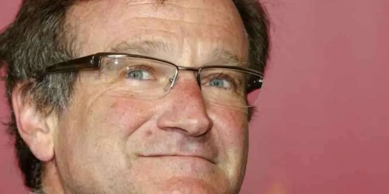 Primo piano di Robin Williams con occhiali, un uomo che ha portato gioia a molti, anche se il suo figlio morto non ha potuto vederlo.