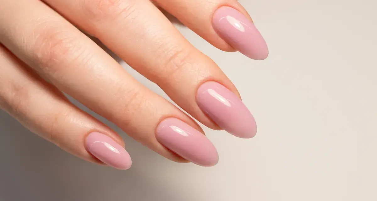 Mano con unghie naturali rosa pallido, forma a mandorla.