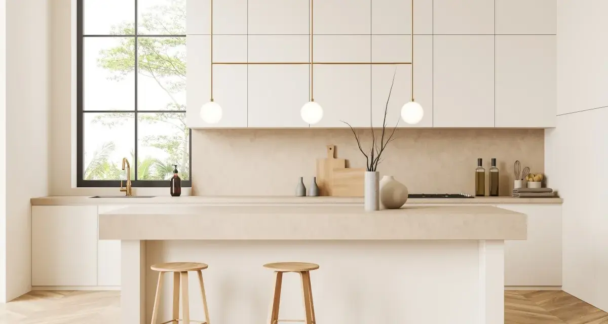 Cocina moderna y luminosa con isla central, taburetes de madera y detalles dorados. Perfecta para decorar cocina con estilo minimalista.