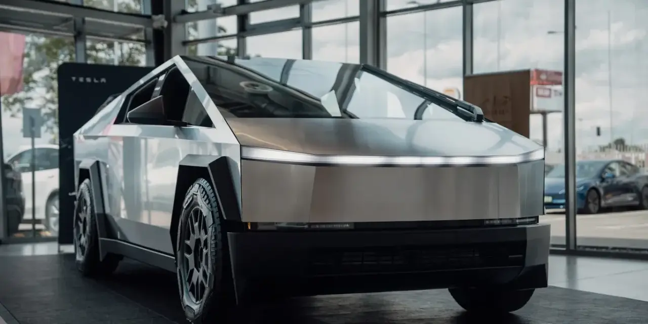 Tesla Cybertruck w salonie Tesli, z widokiem na ulicę przez okno.