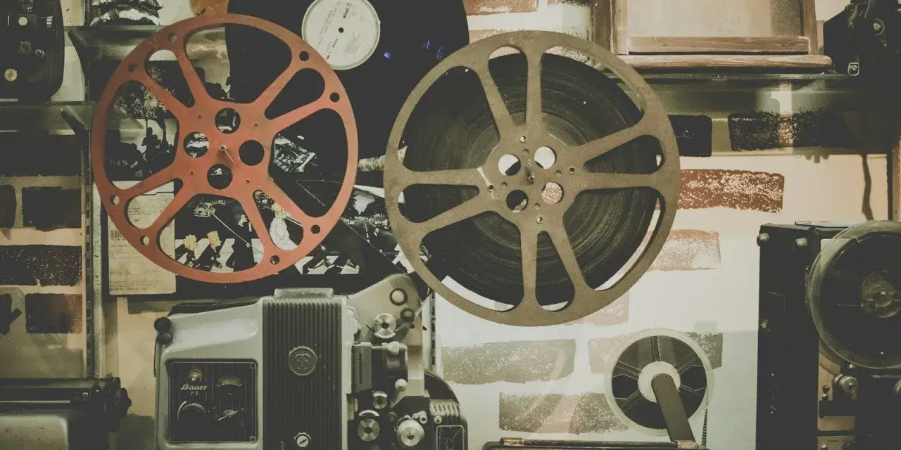 Stare klisze filmowe i projektor, gotowe do odtworzenia historii pełnej emocji i dramatów.
