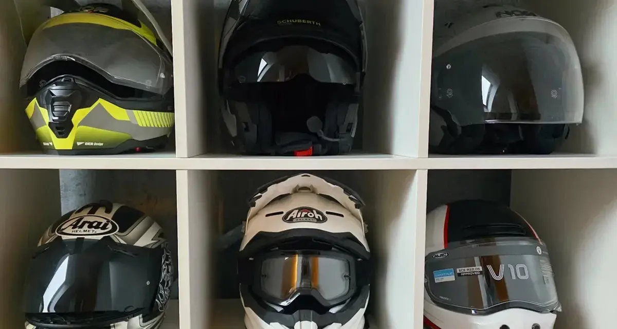 Różne rodzaje kasków motocyklowych: szczękowy, integralny, enduro i crossowy. Kolekcja na półce.