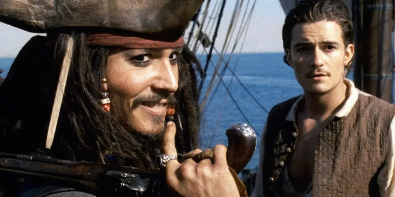 Jack Sparrow, z fajką i karabinem, uśmiecha się do Willa Turnera. Pewnie myśli o kolejnej butelce rumu.