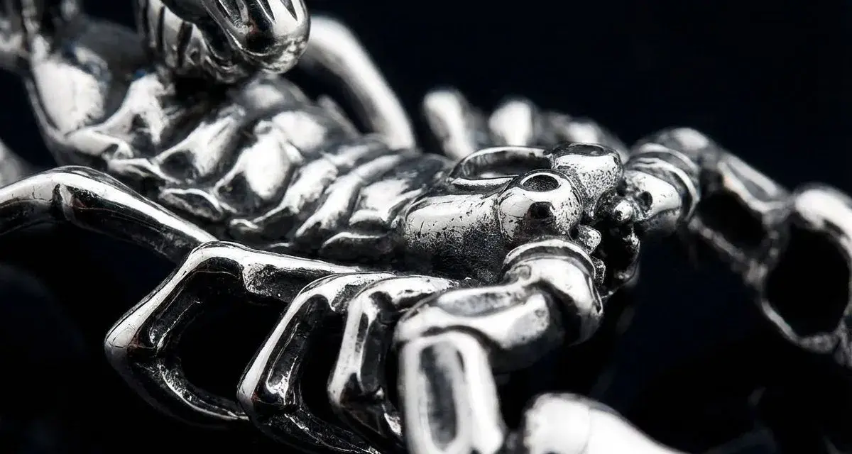 Metalowy symbol skorpiona, z detalami odwzorowującymi jego pancerz i szczypce.