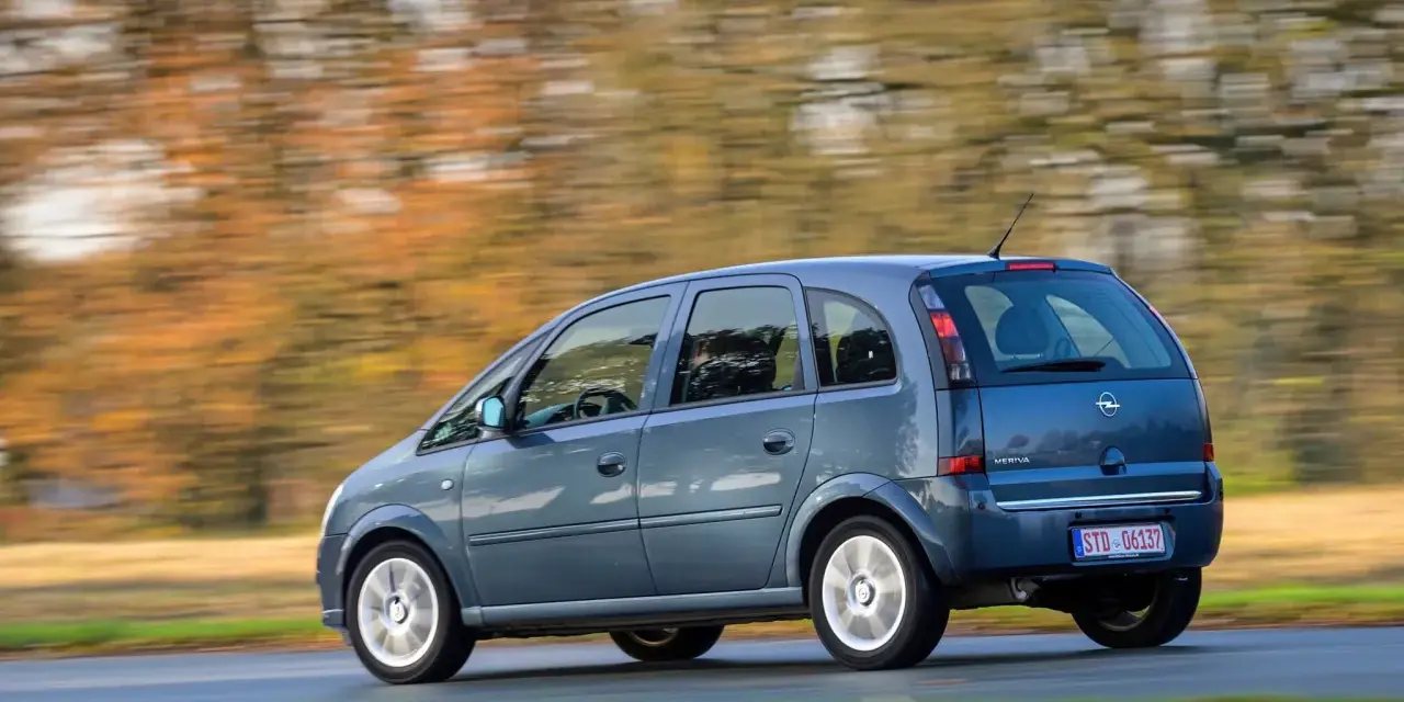 Blauer Opel Meriva A fährt durch eine herbstliche Landschaft. Bekannte Opel Meriva A Schwachstellen sind hier nicht sichtbar.