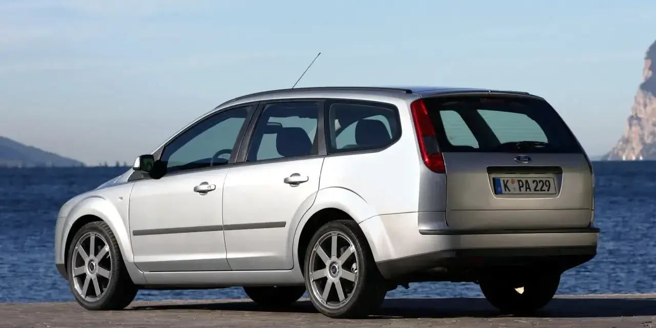 Srebrny Ford Focus MK2 1.6 benzyna na tle morza i skał.