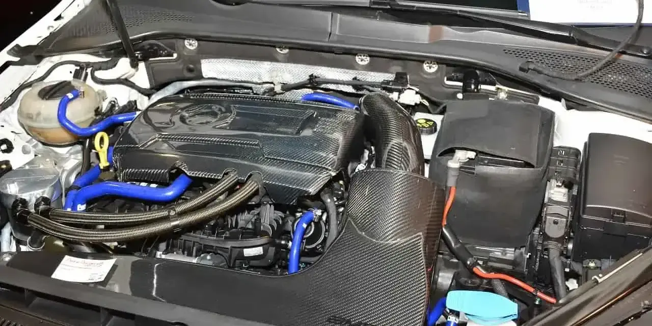 Silnik samochodowy 1.8 TSI z elementami z włókna węglowego i niebieskimi przewodami.