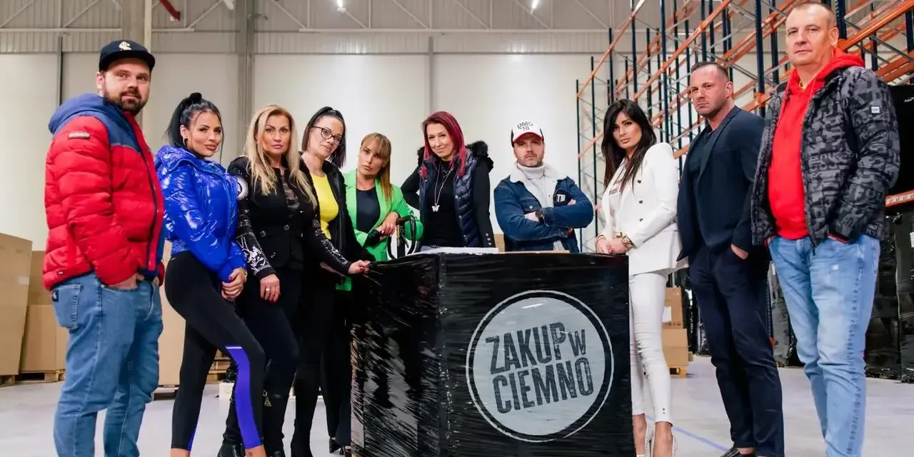 Uczestnicy "Zakup w ciemno" pozują przy palecie z czarną folią.