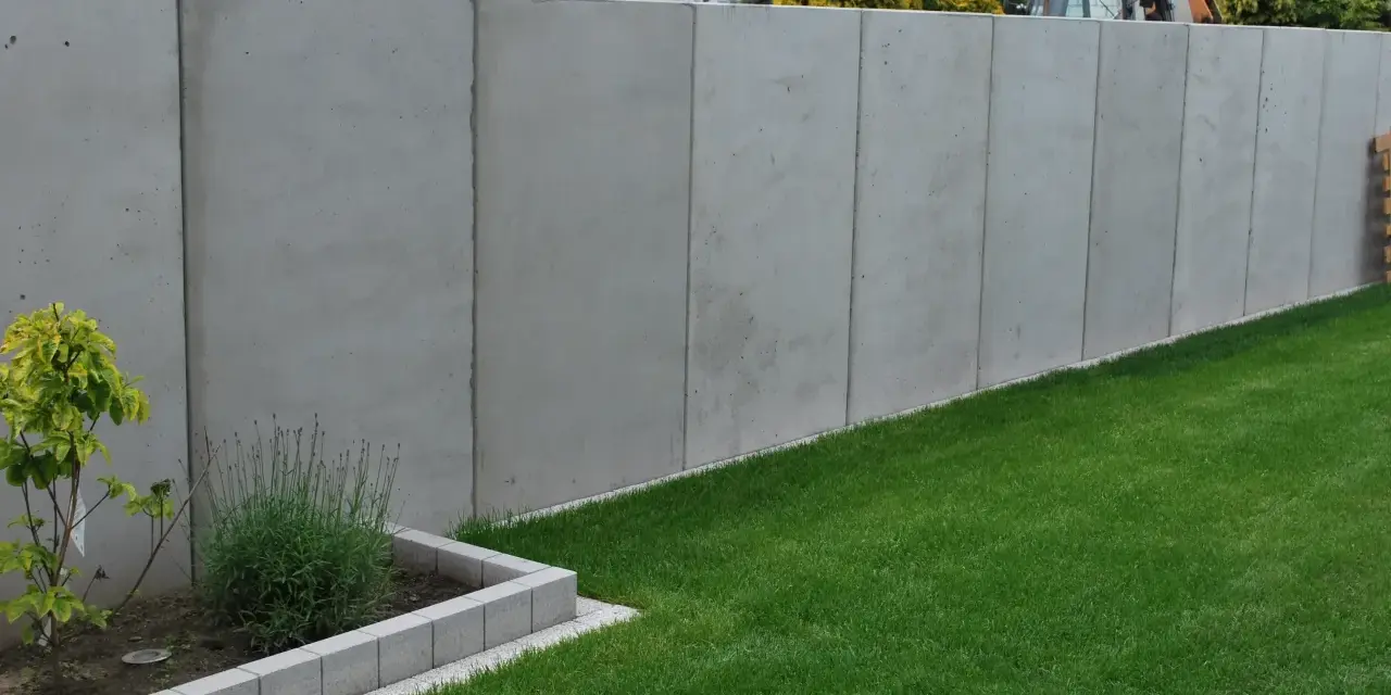 Betonowy mur wysoki na 2,2m. Unikaj najgorszych błędów przy zgłaszaniu budowy ogrodzenia powyżej 2,2 metra po nowym prawie.
