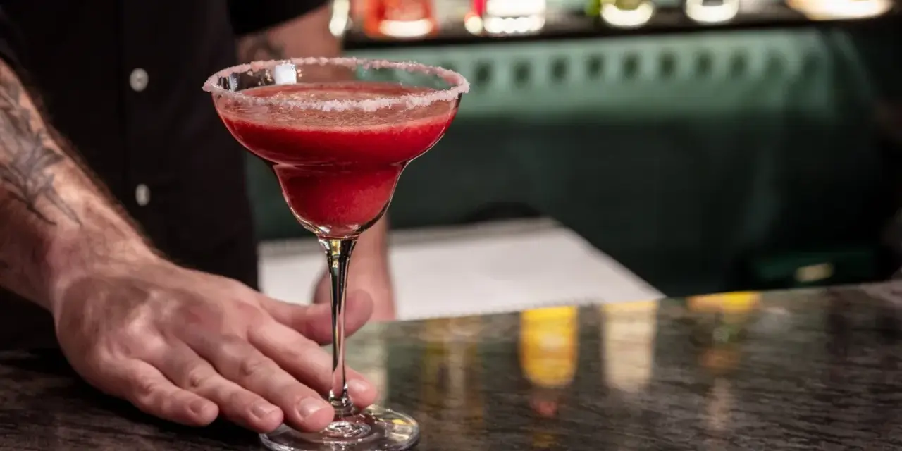 Margarita przepis: orzeźwiający, czerwony drink z solą na brzegu kieliszka, podawany przez barmana.