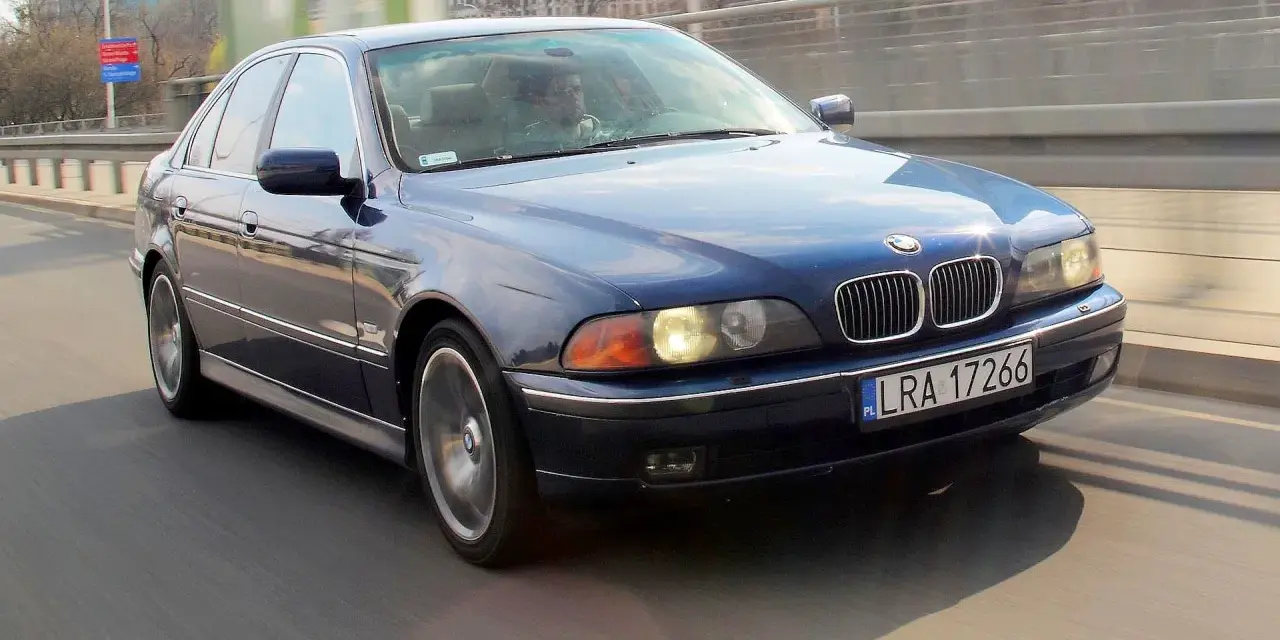 Niebieskie BMW serii 5 (E39) z silnikiem m52b20 jedzie po moście.