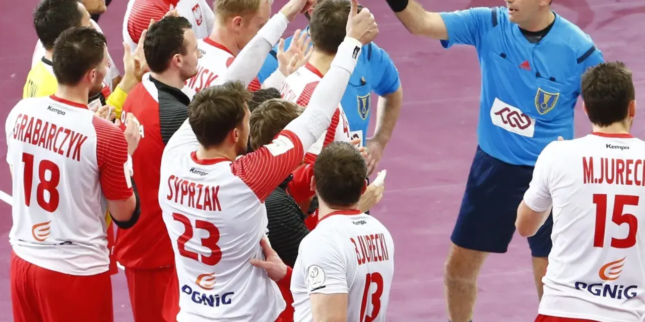 Polska kadra piłka ręczna świętuje zwycięstwo. Zawodnicy w białych strojach z czerwonymi detalami, z numerami 18, 23 i 15, cieszą się z sukcesu.