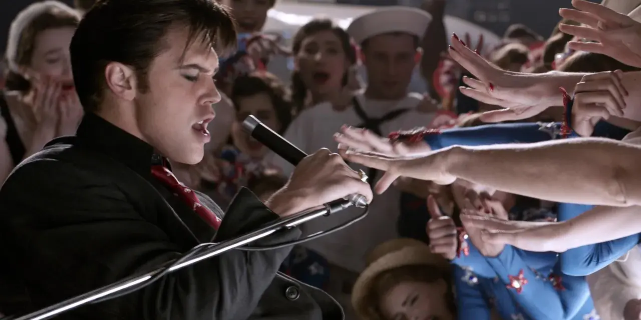 Elvis Presley, der Film: Ein junger Elvis singt mit Leidenschaft ins Mikrofon, umringt von jubelnden Fans.