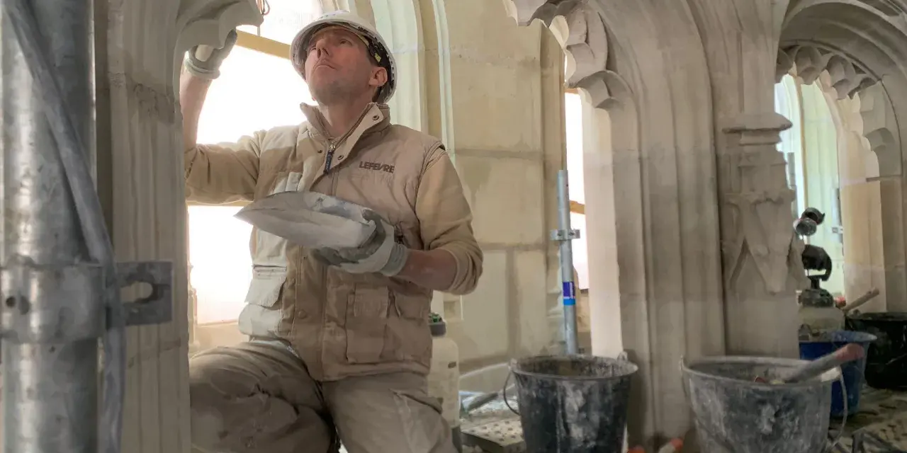 Un maçon restaure la voûte de la cathédrale de Nantes, un chantier qui suit l'incendie.