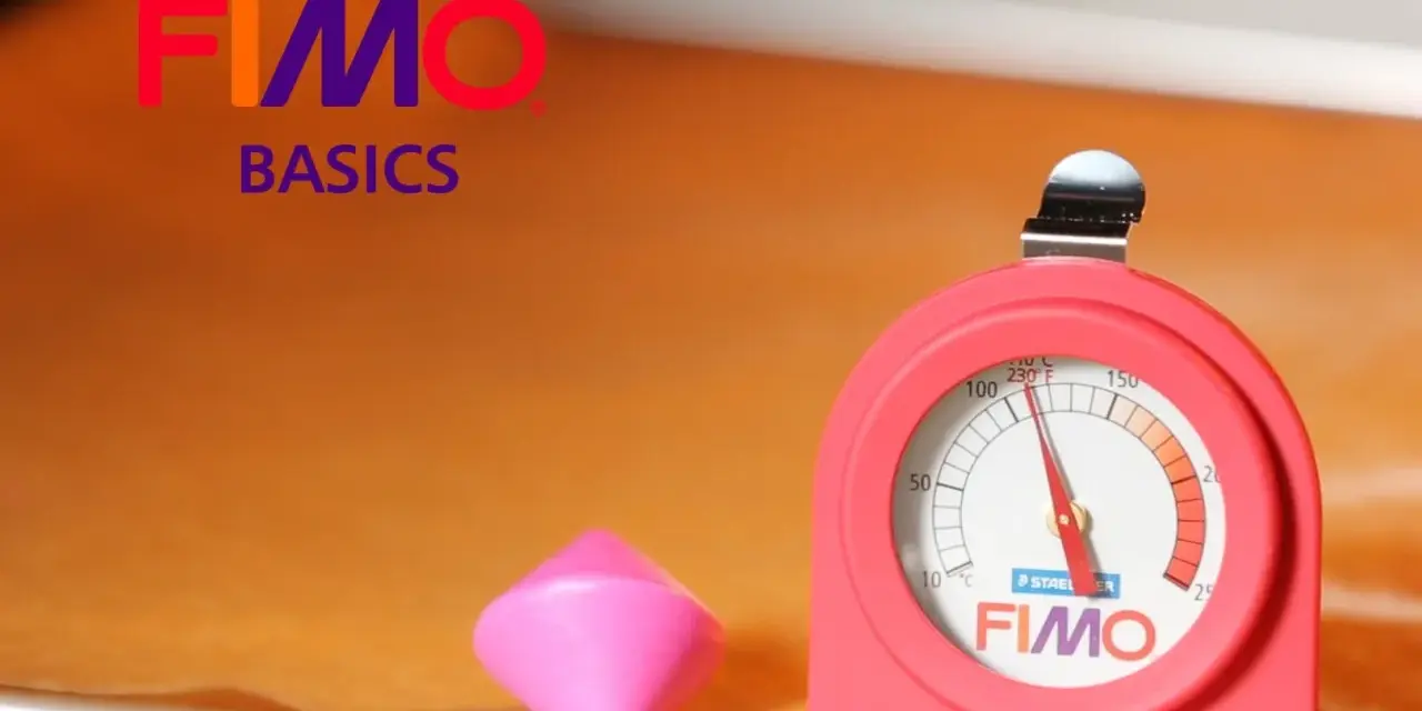 Termometro per forno per fimo, accanto a un pezzo di pasta modellabile rosa.
