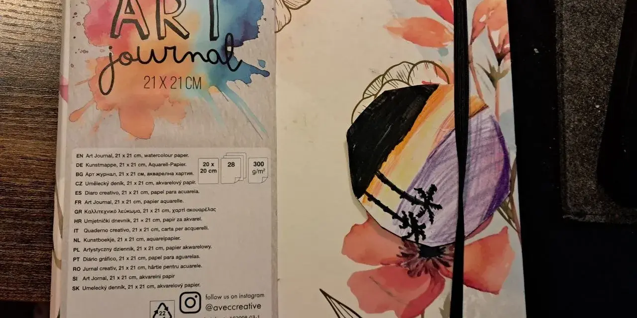 Pierwsza strona szkicownika z napisem "ART journal" i kolorowymi kwiatami. Na okładce widoczny fragment rysunku.