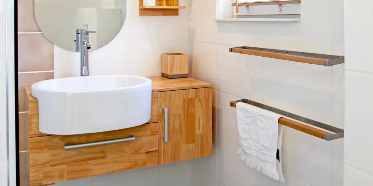 Meuble de salle de bain en bois clair, avec vasque blanche et robinetterie moderne. La hauteur du meuble est idéale pour un accès facile.