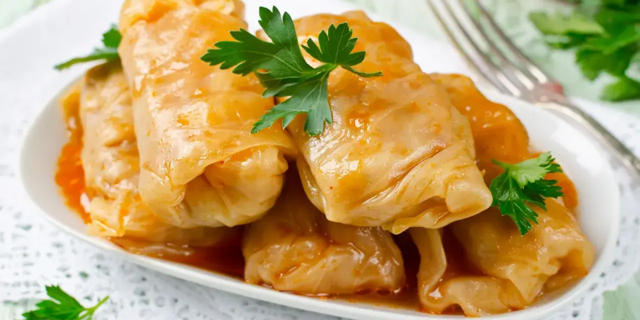 Talerz gołąbków w sosie, udekorowany natką pietruszki. Zastanawiasz się, ile kcal ma gołąbek?