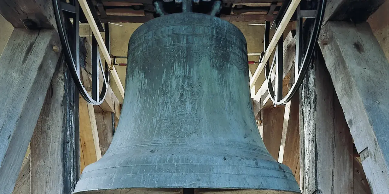 Große, grüne Kirchenglocke im Glockenturm, bereit zum Läuten an Ostern.