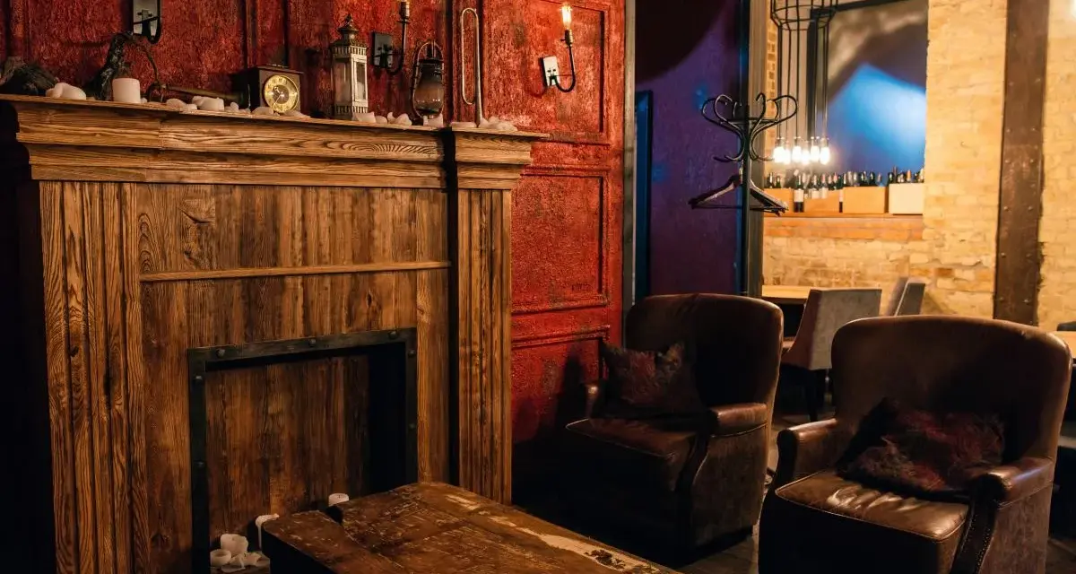 Drewniany kominek, skórzane fotele i lampy tworzą atmosferę **steampunk**.