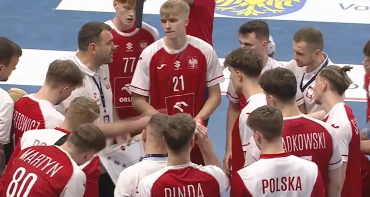 Drużyna PGNiG piłka ręczna w czerwonych strojach słucha trenera.