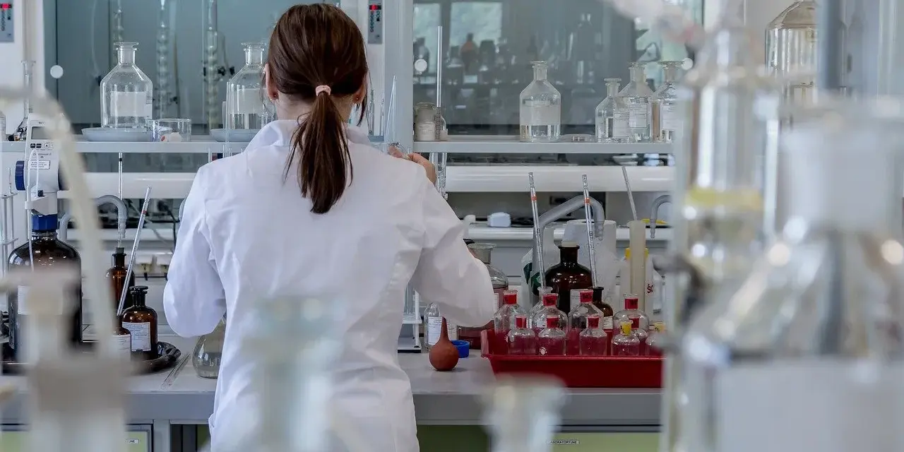 Naukowczyni w białym fartuchu pracuje w laboratorium chemicznym, przygotowując eksperyment. To kluczowy etap, jak otworzyć laboratorium chemiczne.