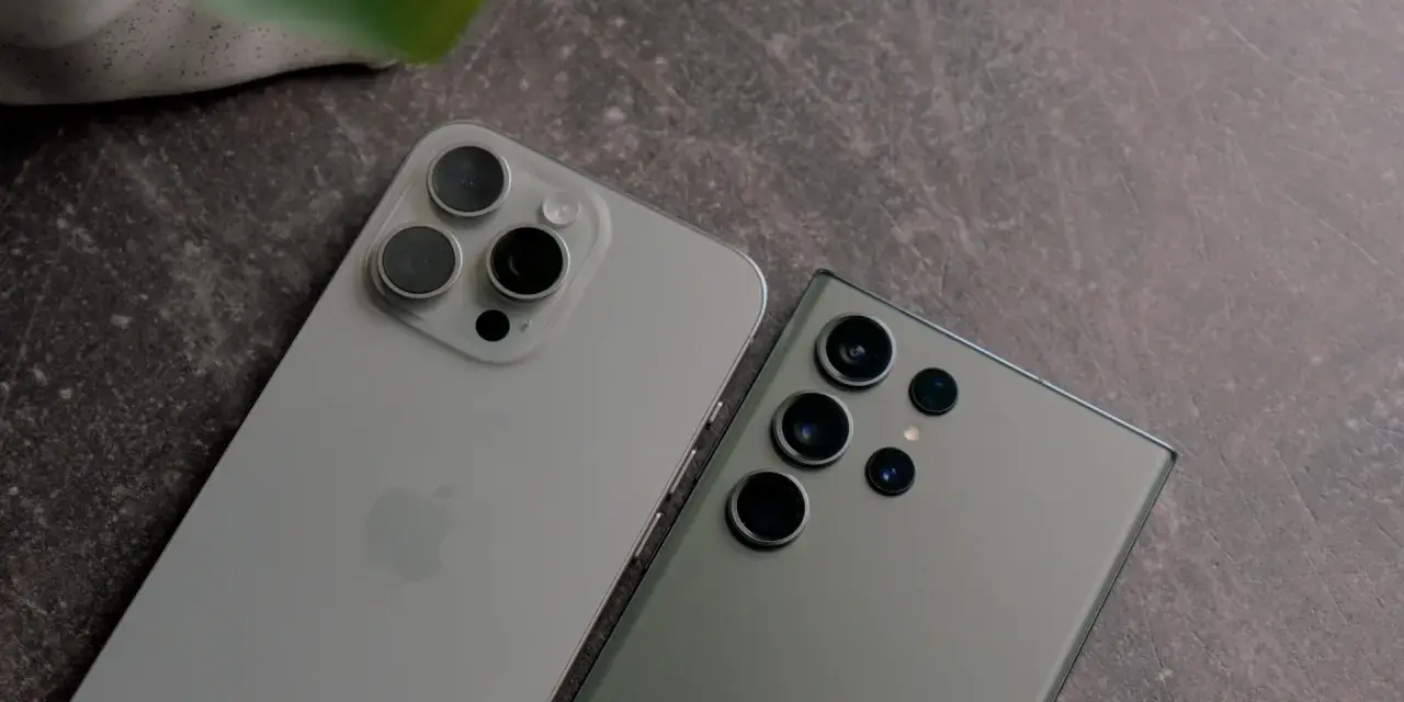 Dwa najnowsze fotosmartfony, iPhone i Samsung, leżą obok siebie na ciemnym tle.