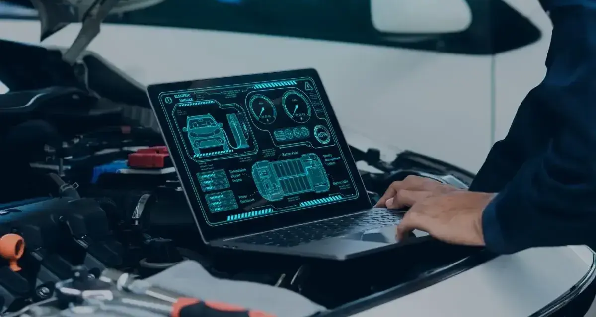 Diagnostyka komputerowa samochodu cena: mechanik analizuje dane z laptopa dotyczące elektrycznego pojazdu.