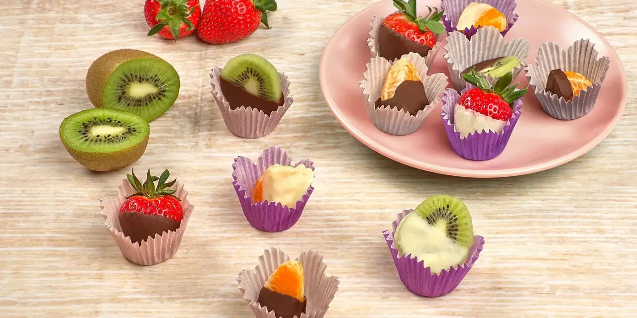 Fruktbitar doppade i choklad och vit choklad, serverade i färgglada cupcake formar. Jordgubbar, kiwi och apelsin.