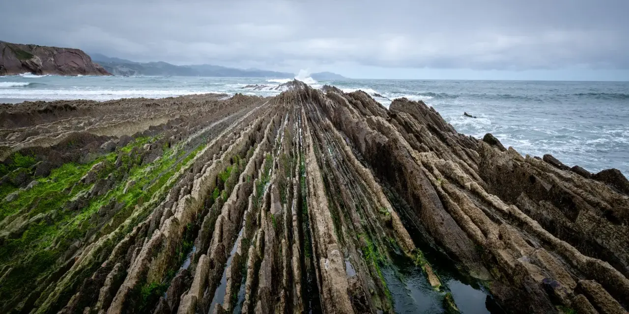 Dramatic rock formations on a rugged coastline, a perfect spot for day trips from Bilbao.