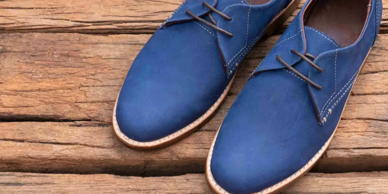 Un paio di eleganti scarpe blu con lacci marroni, perfette per completare un abito blu.