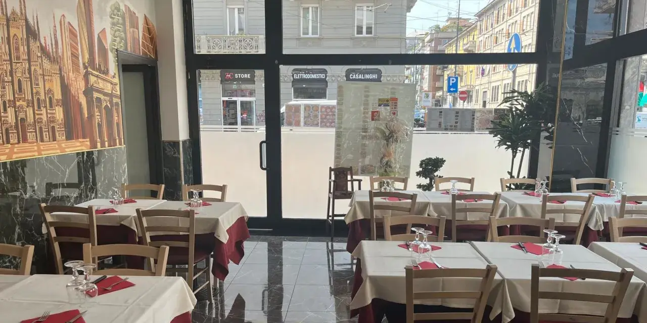 Restaurant interior with tables set for dining, featuring a mural of Milan's skyline.
