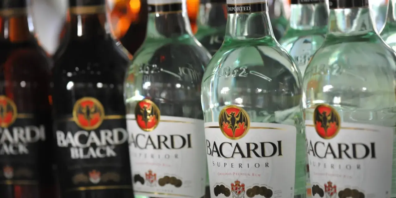 Rzędy butelek Bacardi, w tym Bacardi Black i Bacardi Superior. Bacardi to znany alkohol, rum.