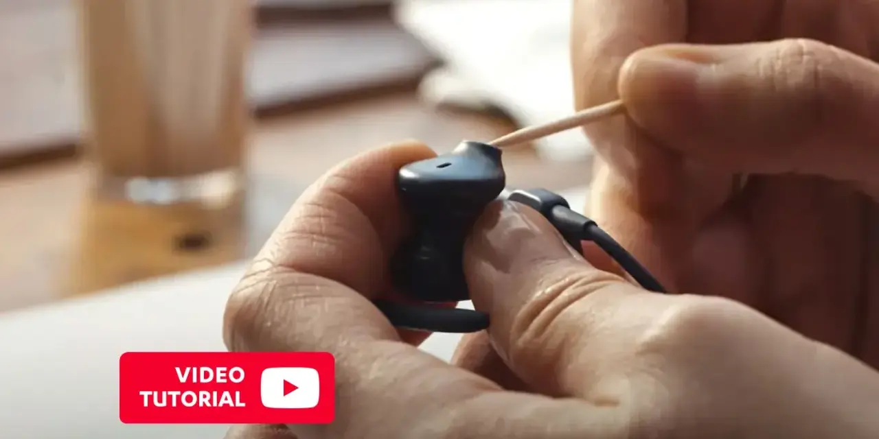 Pokazano, jak wyczyścić słuchawki douszne za pomocą wykałaczki. Wideo tutorial.