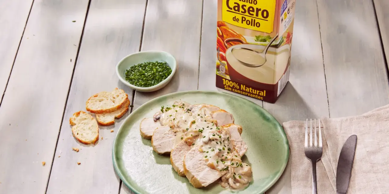 Lonchas de solomillo de pavo con salsa cremosa de champiñones, acompañadas de pan tostado y cebollino picado.