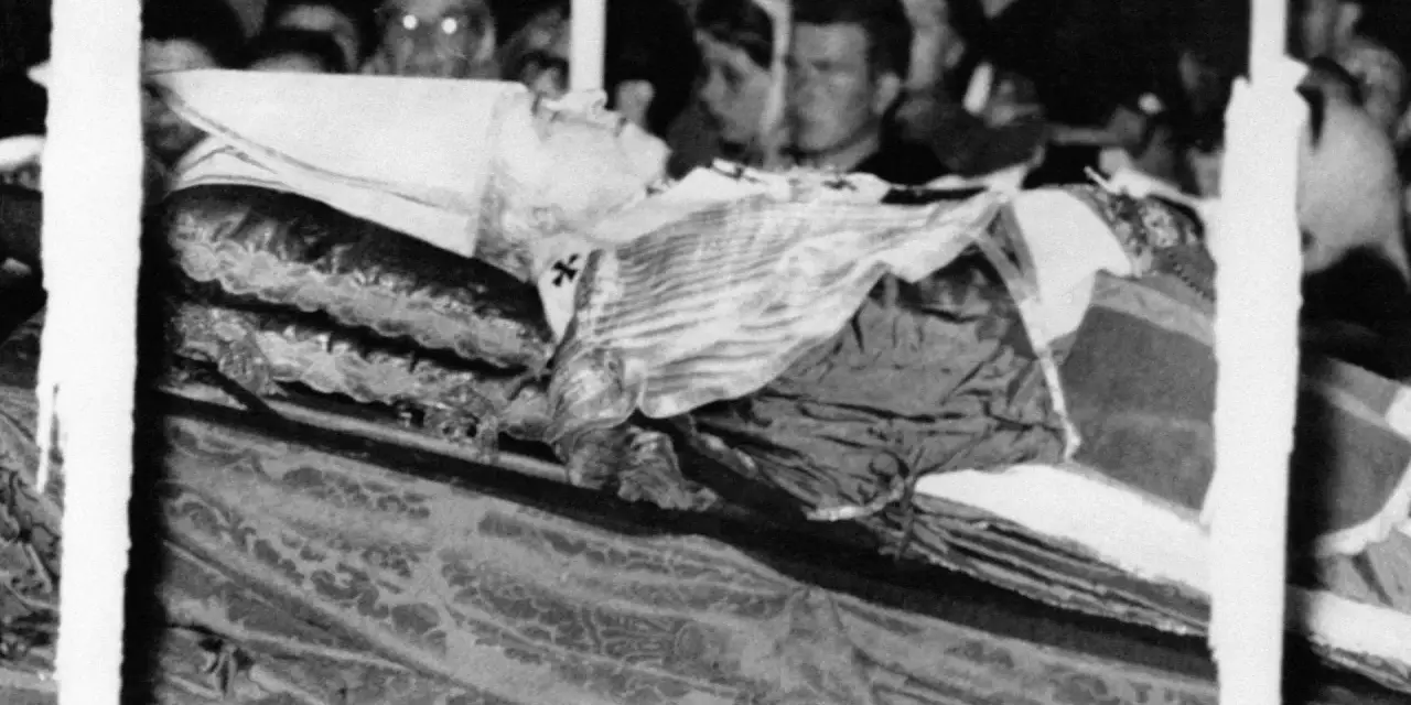 Pius XII w szatach, przygotowany do balsamowania. Tłum ludzi w tle.