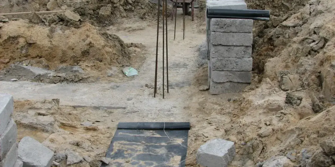 Budowa domu. Kopanie pod fundamenty, zbrojenie i pierwsze warstwy bloczków betonowych.