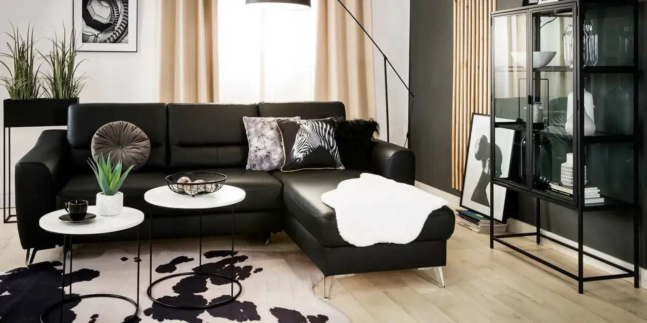 Nowoczesny salon z czarną kanapą i dywanem w cętki. Inspiracje dla odważnych aranżacji.