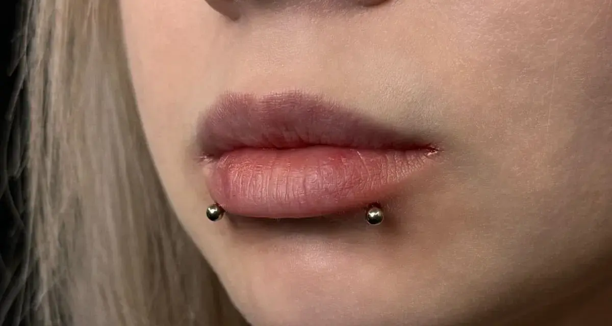 Cyber bites piercing na ustach, podkreślający ich kształt.