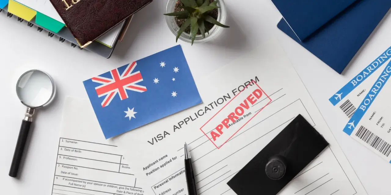 Paszport, formularz wizowy z pieczątką "APPROVED", flaga Australii, bilety lotnicze.